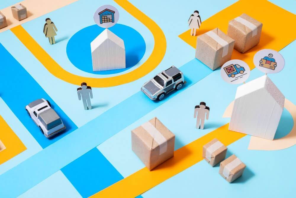 Conceptual flat lay featuring miniature vehicles, packages, and figures arranged on a map, visualizing the movement and management of goods within the three pillars of logistics flow