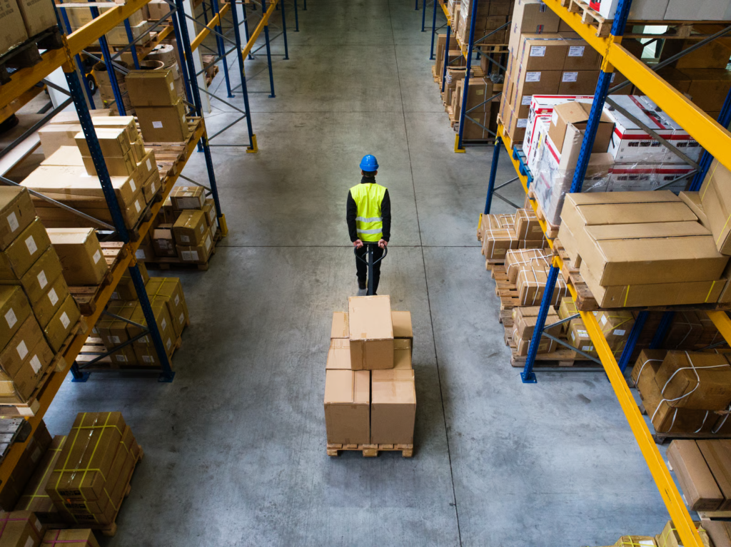 Worker pulling cart of boxes